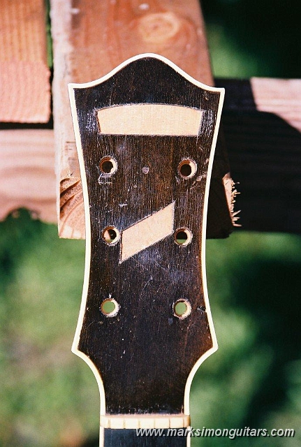 R1-02043-005A.jpg - Missing pearl & open back center seam when it came in. This guitar belonged to Roma's father until she inherited it. Roma's childhood memories remembered that this guitar was a D'Angelico and that it was an A-1. It had been stored in Roma's mother's attic for years and the back seam blew apart. The pearl got dislodged when her cousins visited by dragging it on the floor.